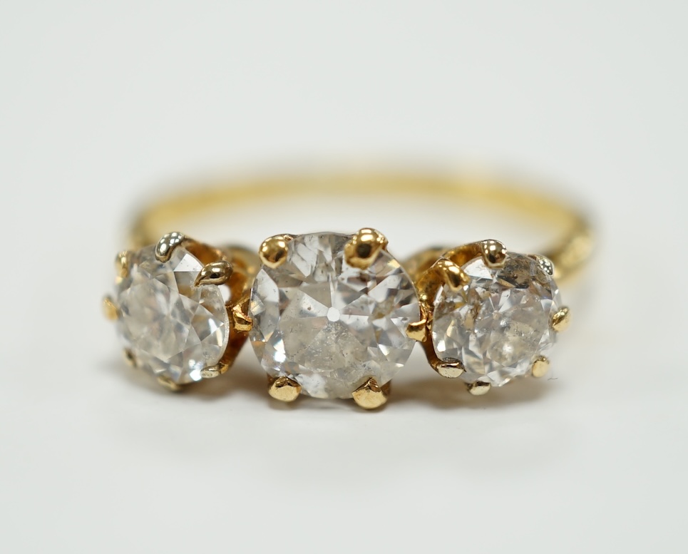 A George V 18ct gold and three stone diamond set ring, the central stone weighing approx. 0.60ct, size L, gross weight 2.5 grams.